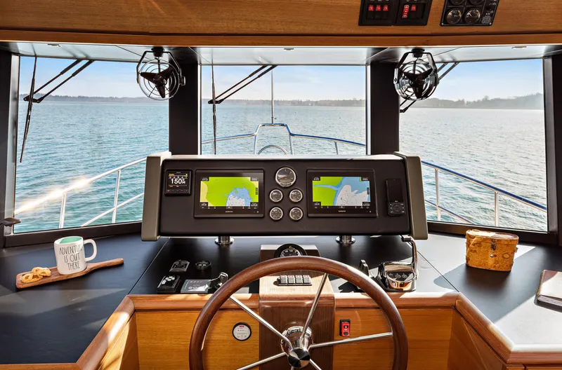Slide: The Image of Pilothouse interior of 2025 North Pacific 450, featuring navigation screens and steering wheel. - 30