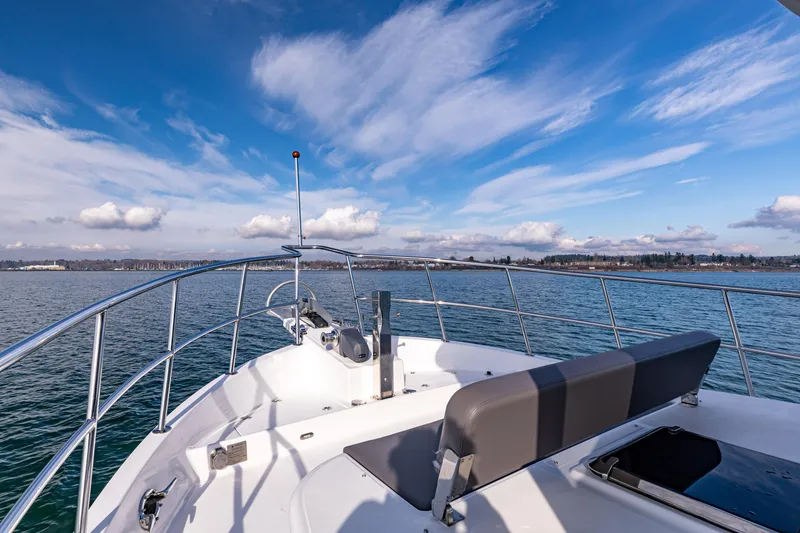 Slide: The Image of 2025 North Pacific 450 Pilothouse boat on calm water under a clear blue sky. - 33