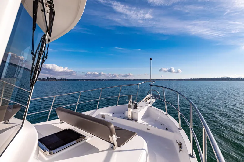 Slide: The Image of 2025 North Pacific 450 Pilothouse yacht cruising on calm blue waters under a clear sky. - 34