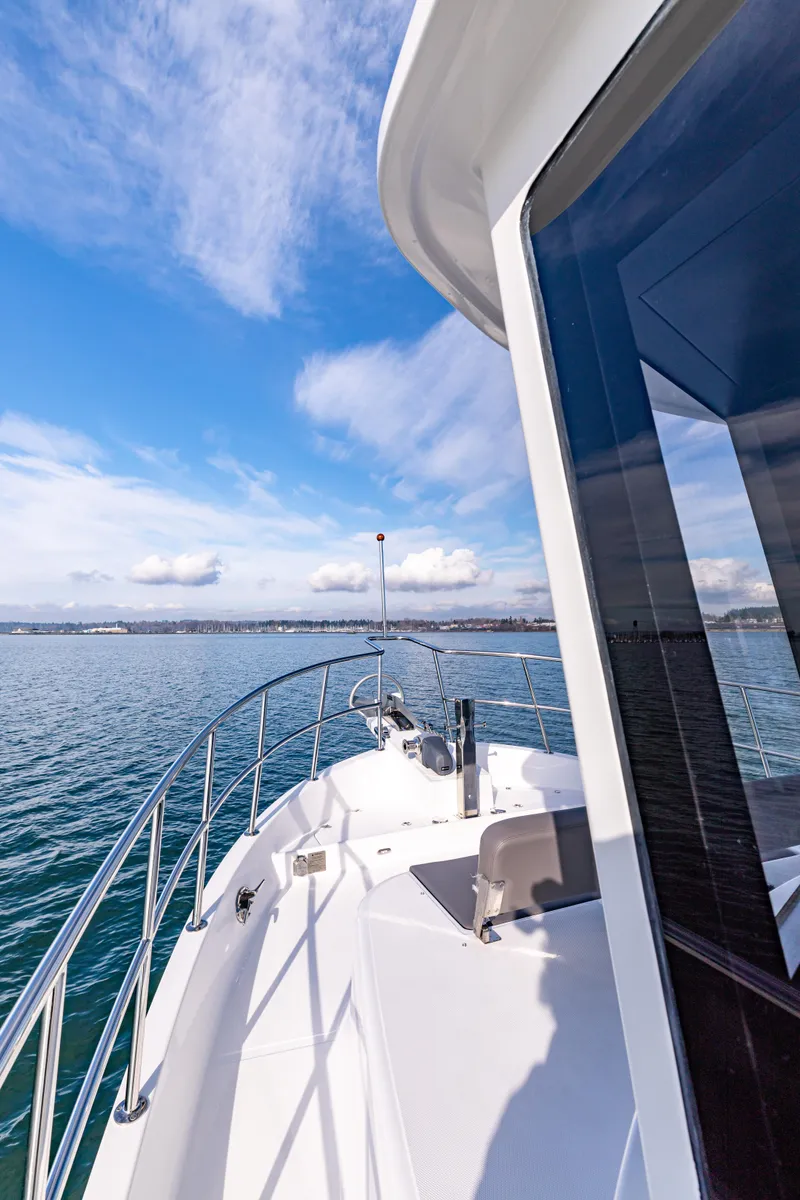 Slide: The Image of 2025 North Pacific 450 Pilothouse cruising on open water under a clear blue sky. - 35