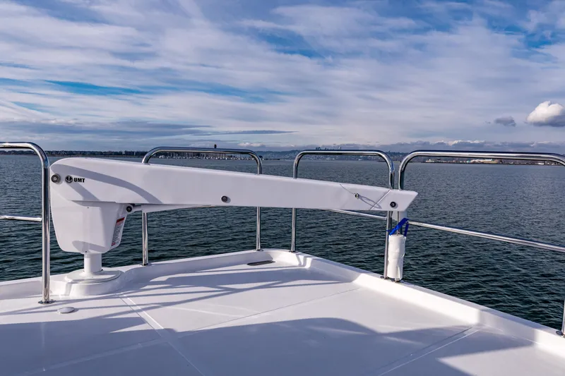 Slide: The Image of North Pacific 450 Pilothouse 2025 yacht deck with crane, overlooking calm sea and cloudy sky. - 41