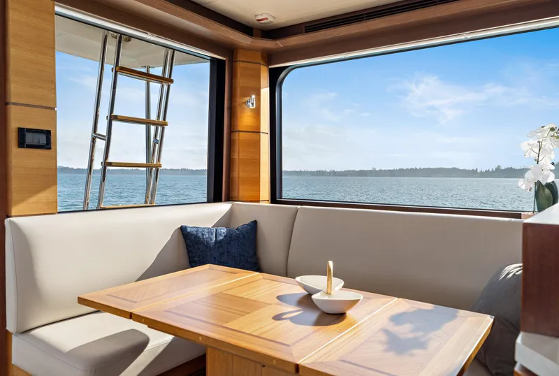 Slide: The Image of Interior of 2025 North Pacific 450 Pilothouse yacht with ocean view through large windows. - 6