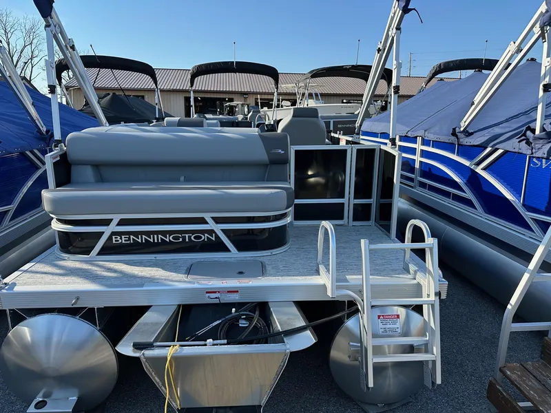 Slide: The Image of 2026 Bennington 188 SLJ pontoon boat, rear view, docked with blue canopy. - 6
