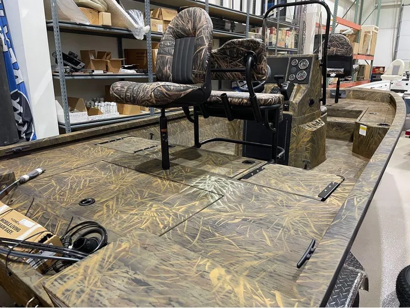 Slide: The Image of 2024 G3 Bay 20 GX boat with camo seats and deck in a warehouse. - 15