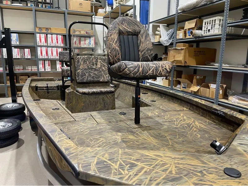 Slide: The Image of 2024 G3 Bay 20 GX boat with camo seats in a storage room. - 20