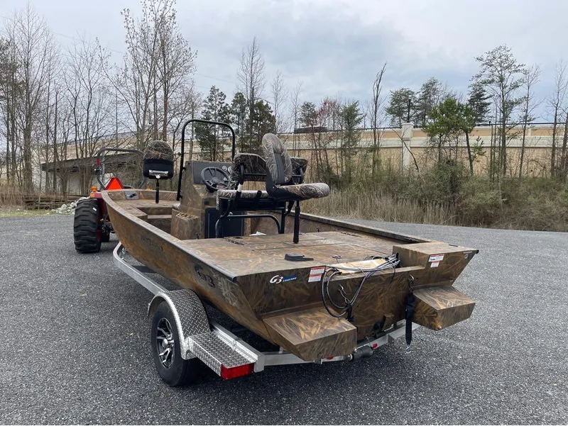 Slide: The Image of 2024 G3 Bay 20 GX boat on trailer, camo design, parked outdoors. - 7