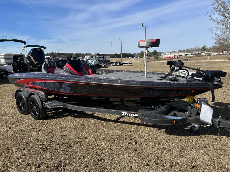 Slide: The Image of 2024 Triton 20XP bass boat on trailer, parked on grass under clear sky. - 10