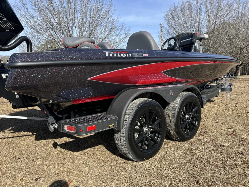 Slide: The Image of 2024 Triton 20XP boat on trailer, black and red design, parked outdoors. - 12