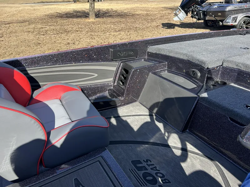 Slide: The Image of 2024 Triton 20XP boat interior with red and gray seating, spacious deck, and storage compartments. - 22