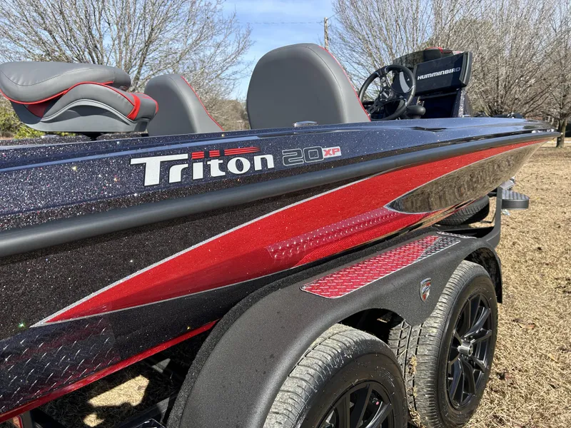 Slide: The Image of 2024 Triton 20XP boat with sleek design and red accents on a trailer. - 5