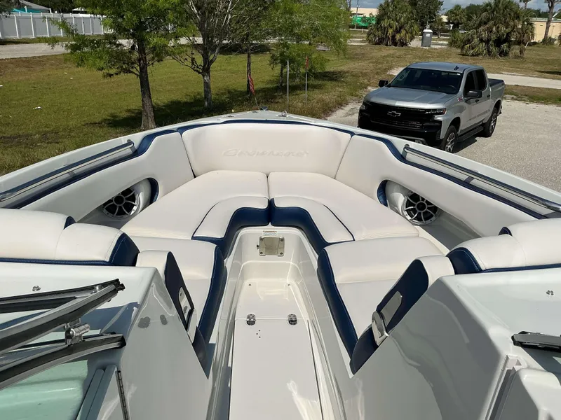 Slide: The Image of 2024 Crownline 270 XSS boat interior with white and blue seating, parked near a truck. - 10