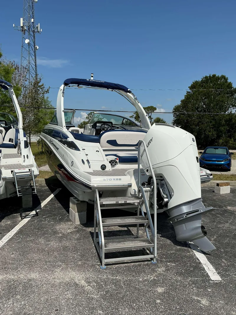 Slide: The Image of 2024 Crownline 270 XSS boat with outboard motor, parked on a sunny day. - 3