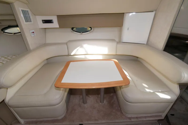 Slide: The Image of 2002 Formula 31 PC boat interior with beige leather seating and a wooden table. - 8