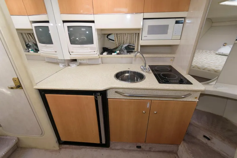 Slide: The Image of 2002 Formula 31 PC yacht kitchen with sink, stove, microwave, and mini-fridge. - 9