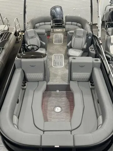 Slide: The Image of 2024 Bennington 25 LTFB pontoon boat with black cover in a warehouse. - 11