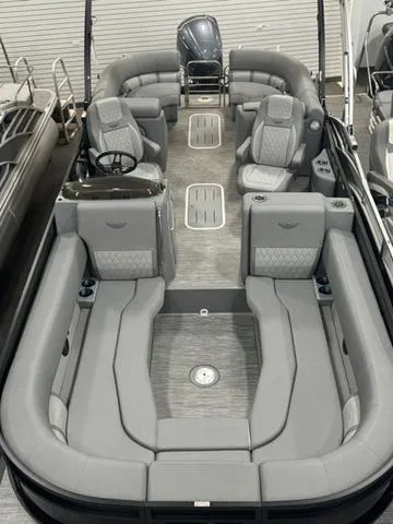 Slide: The Image of 2024 Bennington 25 LTFB pontoon boat in a warehouse, covered with a black tarp. - 12