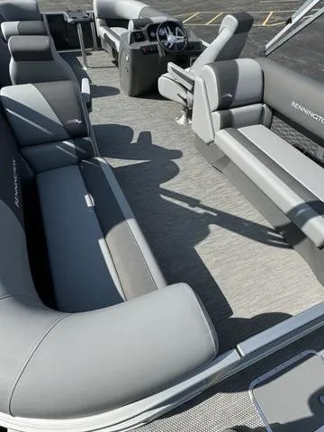 Slide: The Image of 2024 Bennington 22 SSR pontoon boat in a factory setting with a black cover. - 13
