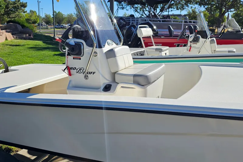 Slide: The Image of 2024 Mako Pro Skiff 13 CC boat with console and seating, displayed outdoors. - 9