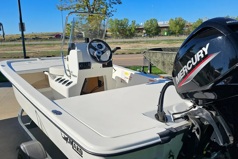 Slide: The Image of 2024 Mako Pro Skiff 13 CC boat with Mercury engine, parked outdoors. - 11