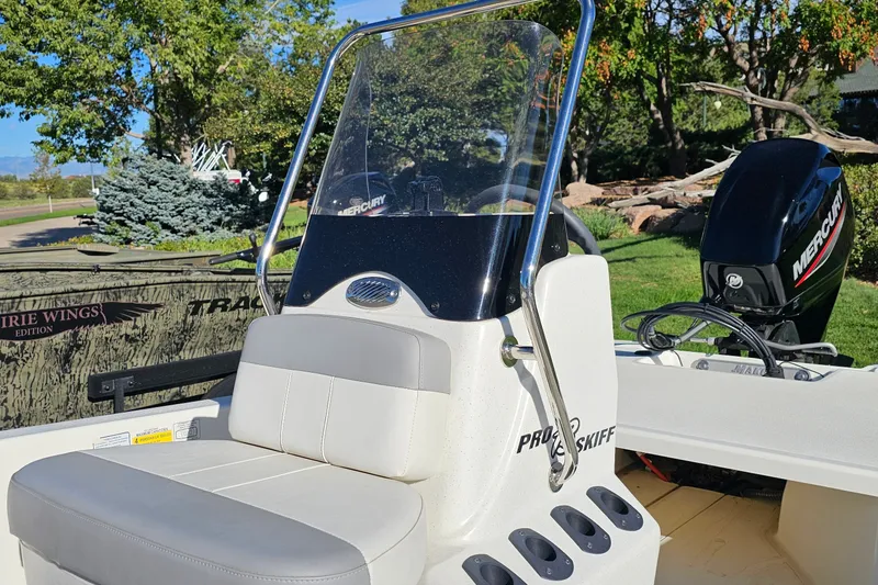 Slide: The Image of 2024 Mako Pro Skiff 13 CC boat with Mercury engine, outdoor setting. - 13