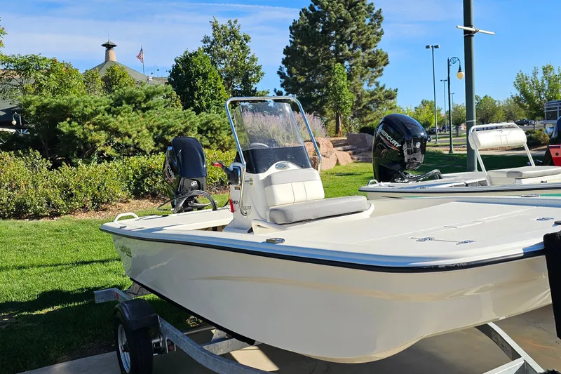 Slide: The Image of 2024 Mako Pro Skiff 13 CC boat on trailer, outdoors in a park setting. - 8