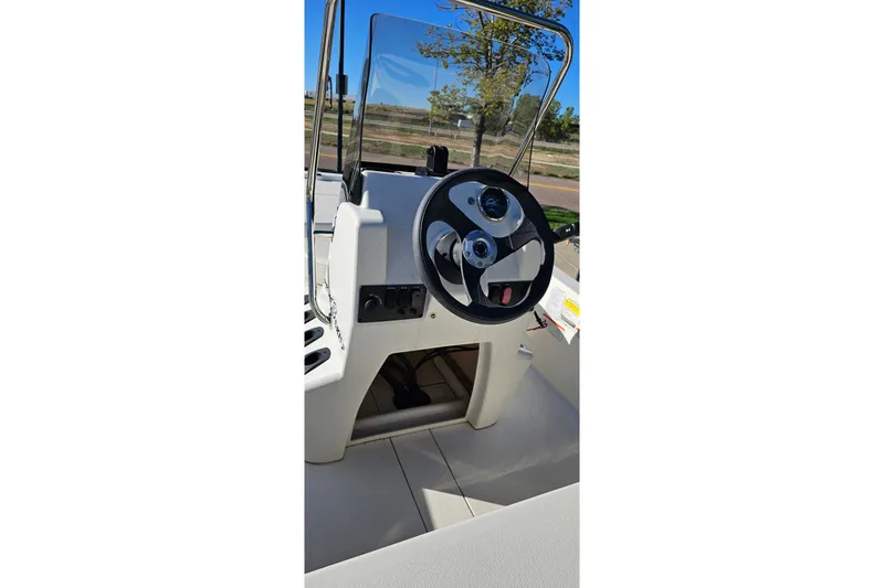 Slide: The Image of 2024 Mako Pro Skiff 13 CC steering console with windshield and controls. - 12
