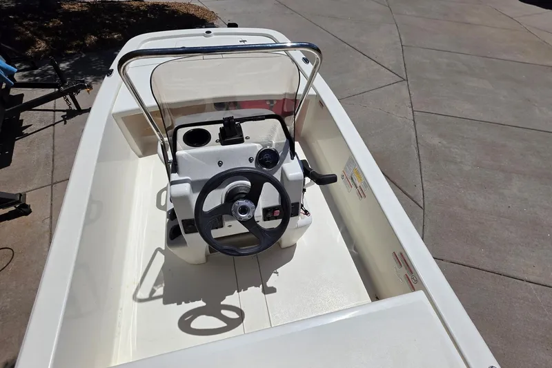 Slide: The Image of 2024 Mako Pro Skiff 13 CC boat interior with steering wheel and console. - 4