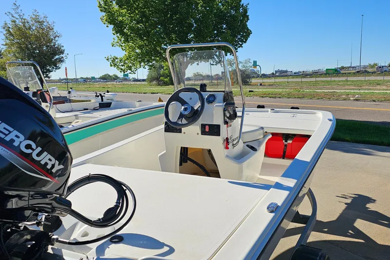 Slide: The Image of 2024 Mako Pro Skiff 13 CC boat with Mercury engine, parked outdoors. - 10