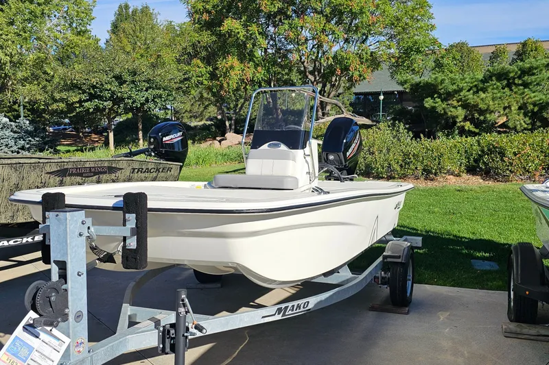 Slide: The Image of 2024 Mako Pro Skiff 13 CC boat on trailer, outdoors in a sunny setting. - 6
