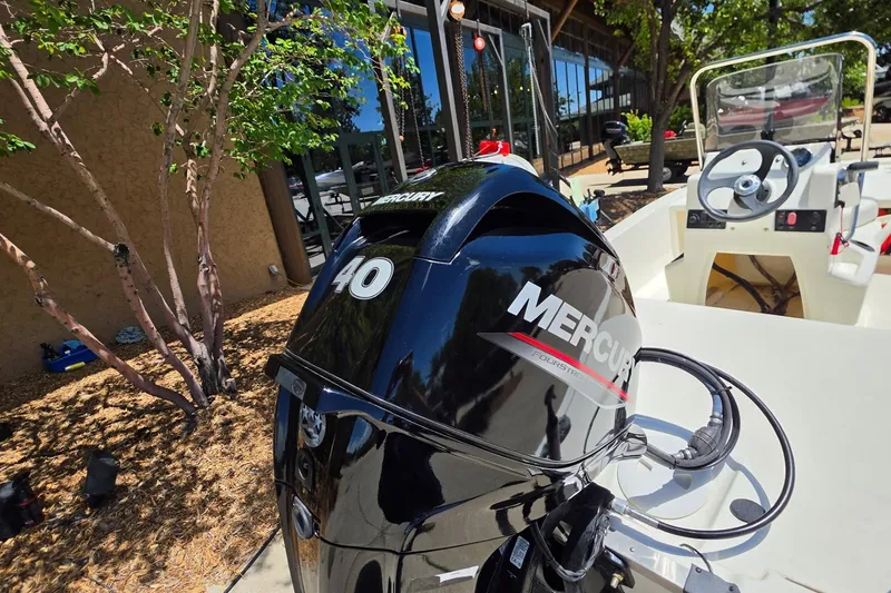 Slide: The Image of 2024 Mako Pro Skiff 13 CC with Mercury 40 outboard motor, parked outdoors. - 5