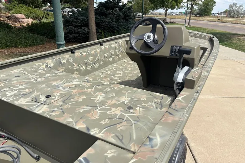 Slide: The Image of 2024 Tracker Grizzly 1648 SC boat with camouflage design and steering console. - 5
