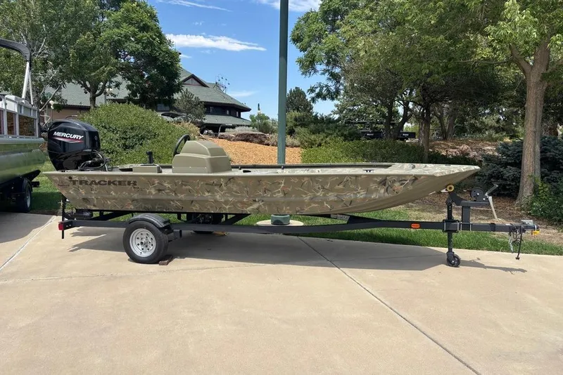 The Image of 2024 Tracker Grizzly 1648 SC boat on trailer, parked outdoors. - 0