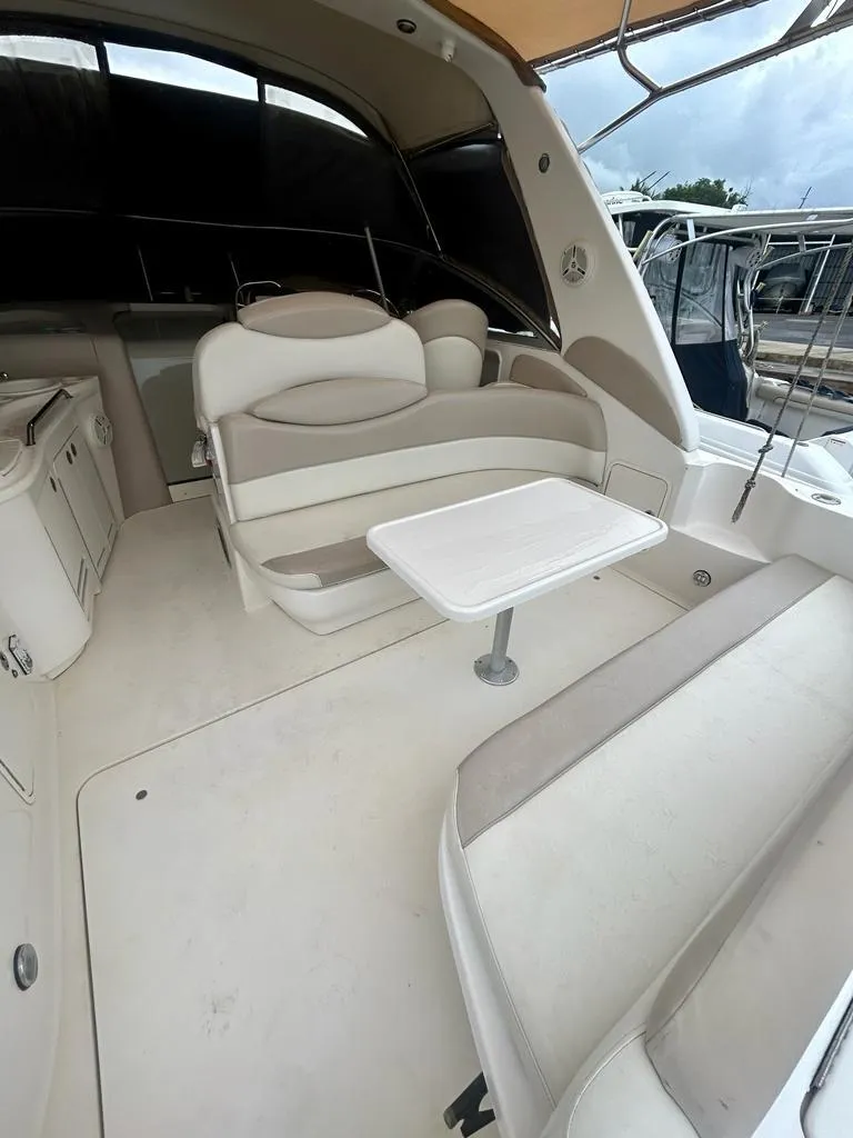 Slide: The Image of 2002 Sea Ray 340 Sundancer boat interior with seating and table, showcasing spacious design. - 10