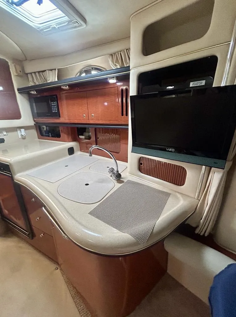 Slide: The Image of Interior of 2002 Sea Ray 340 Sundancer yacht with kitchenette and TV. - 11
