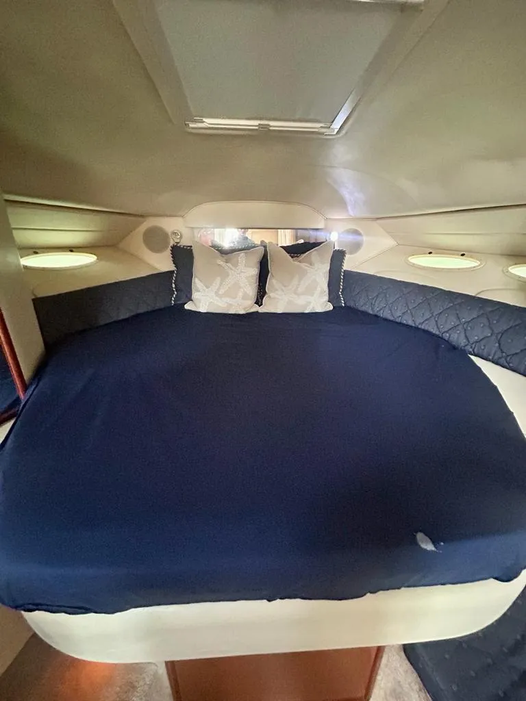 Slide: The Image of Interior cabin of 2002 Sea Ray 340 Sundancer with blue bedding and pillows. - 12
