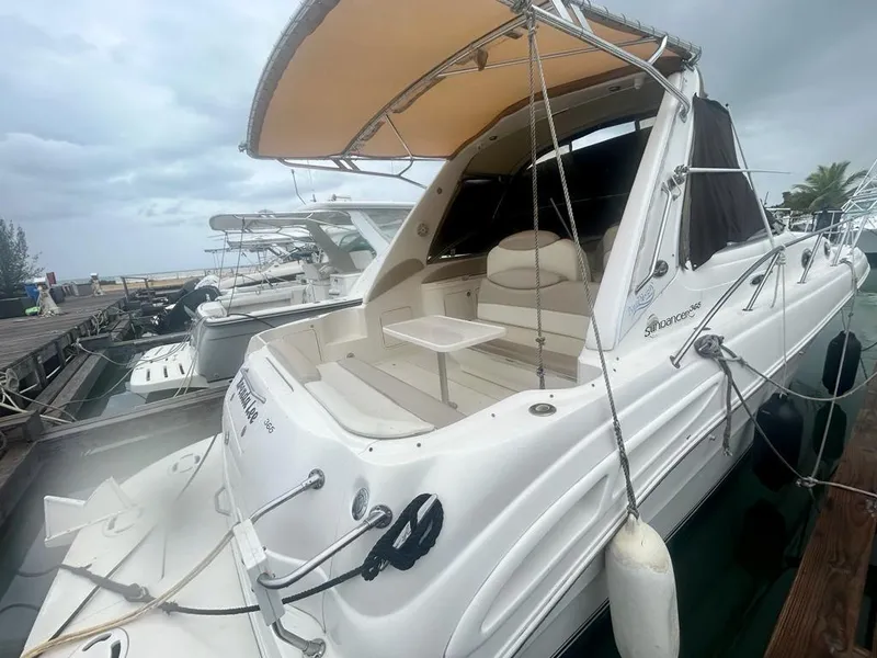Slide: The Image of 2002 Sea Ray 340 Sundancer docked, featuring a spacious deck and canopy. - 2