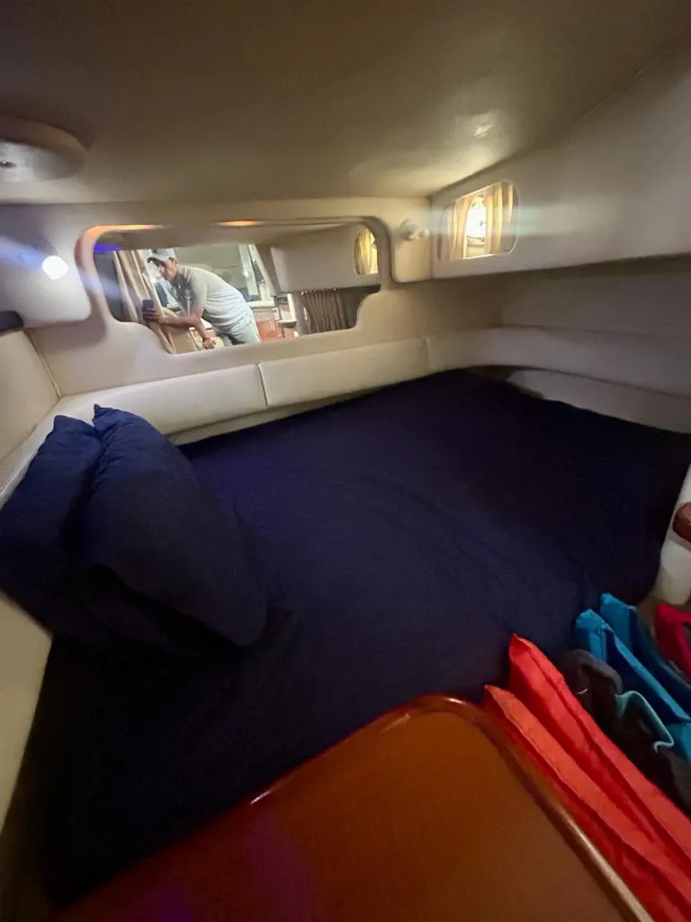 Slide: The Image of 2002 Sea Ray 340 Sundancer cabin interior with cozy bed and ambient lighting. - 5