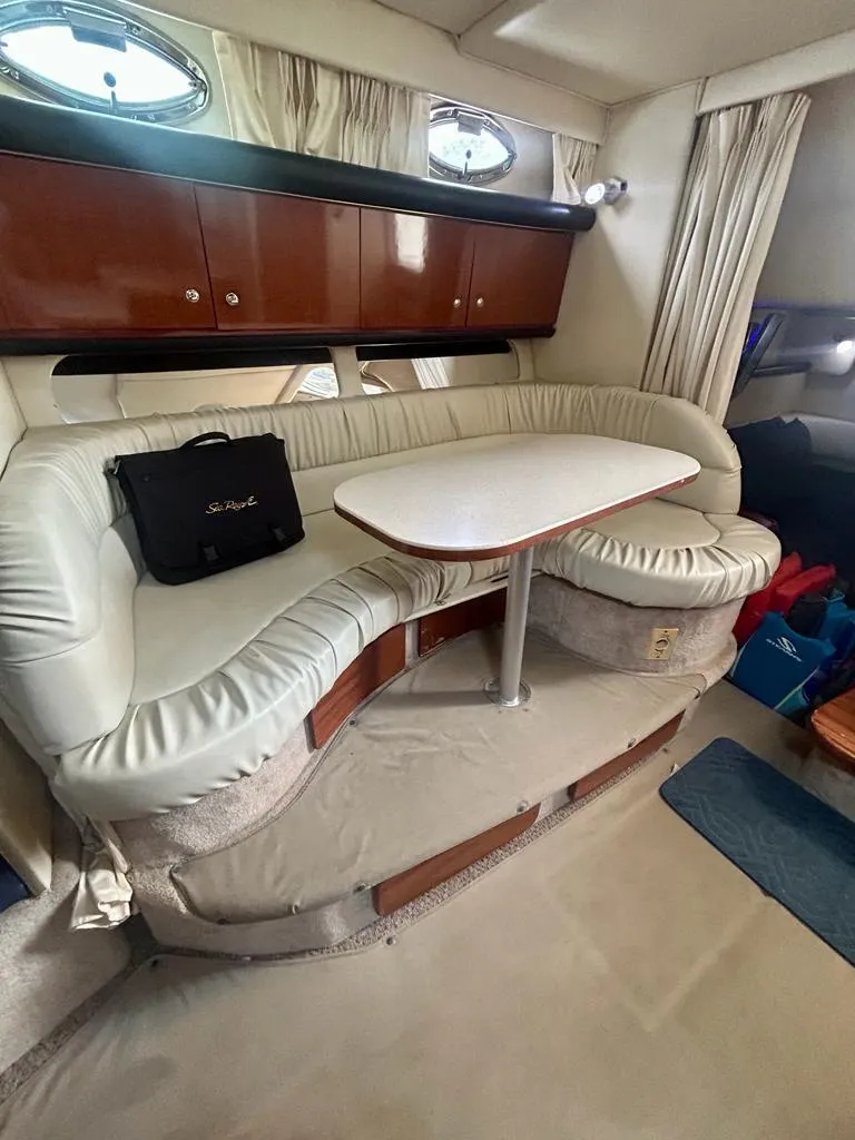 Slide: The Image of Interior of 2002 Sea Ray 340 Sundancer with plush seating and dining table. - 6