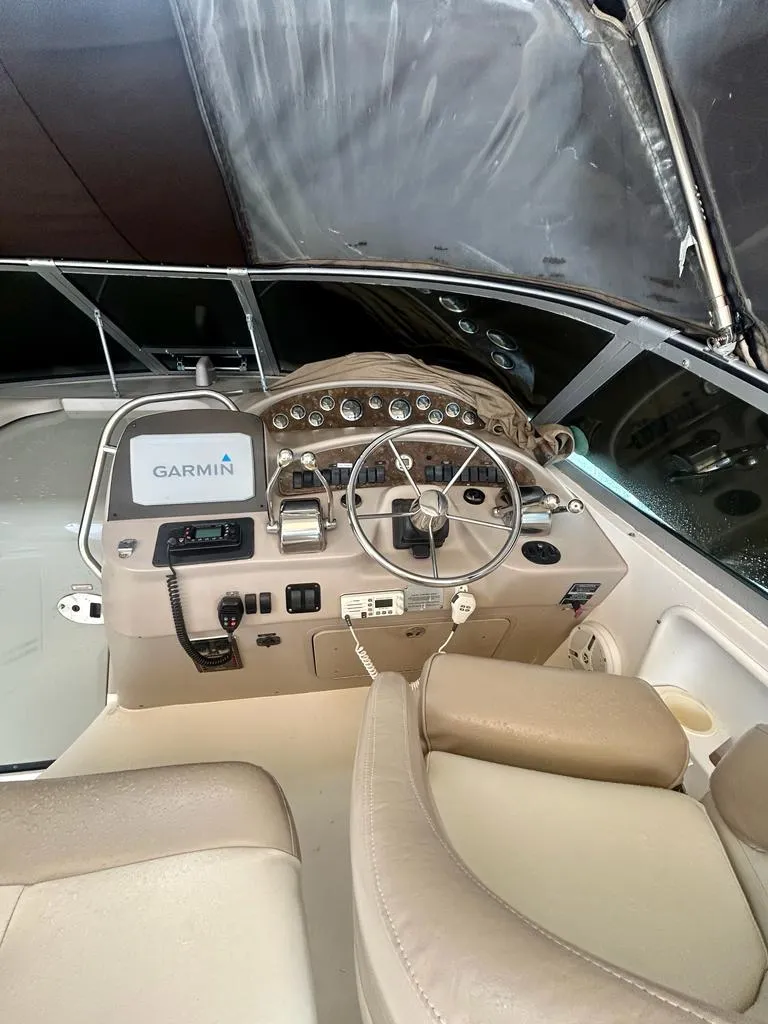 Slide: The Image of 2002 Sea Ray 340 Sundancer helm with Garmin navigation system and beige seating. - 8