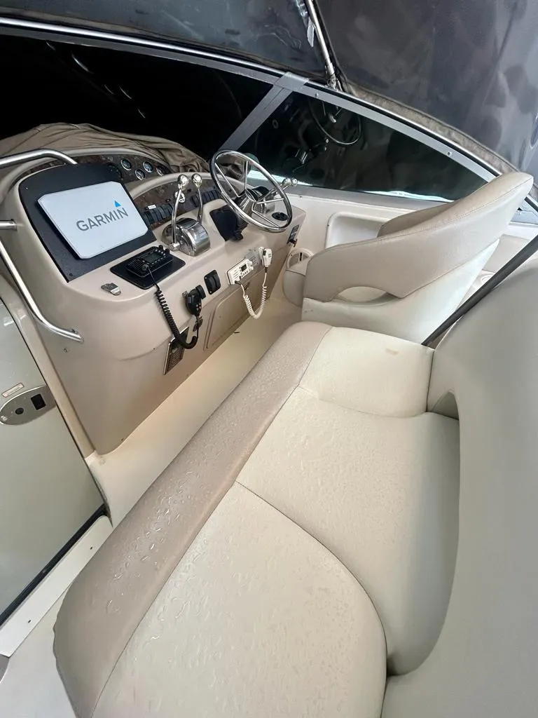 Slide: The Image of 2002 Sea Ray 340 Sundancer helm with Garmin navigation system and beige seating. - 9