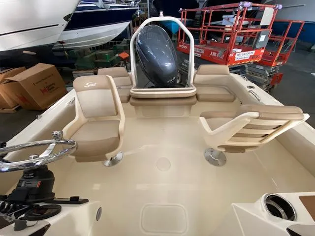 Slide: The Image of 2024 Scout 195 Sport Dorado boat interior with seating and steering wheel in a showroom. - 10