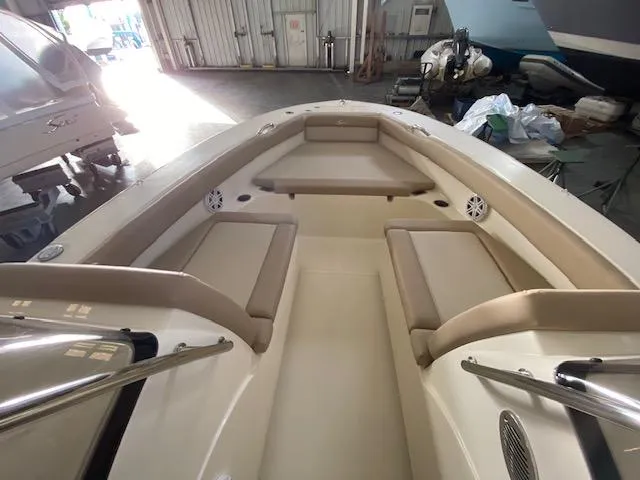 Slide: The Image of 2024 Scout 195 Sport Dorado boat interior with beige seating in a garage setting. - 8