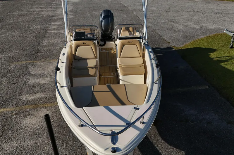 Slide: The Image of 2019 Scout 175 Dorado boat with beige seating, parked on pavement. - 3