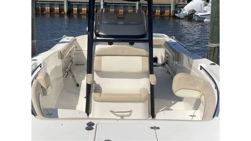 Slide: The Image of 2018 NauticStar 2800 XS boat interior with seating, docked by the water. - 2