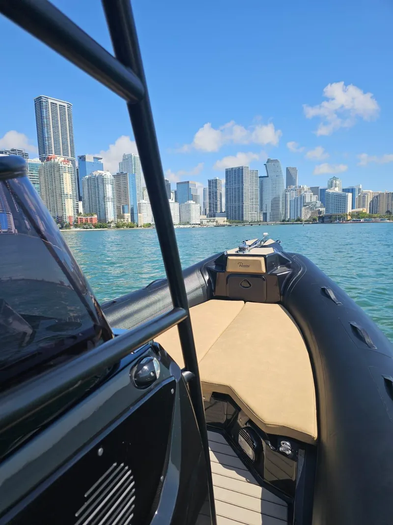 Slide: The Image of 2023 Ranieri CAYMAN 26 SPORT TOURING boat cruising near city skyline. - 9