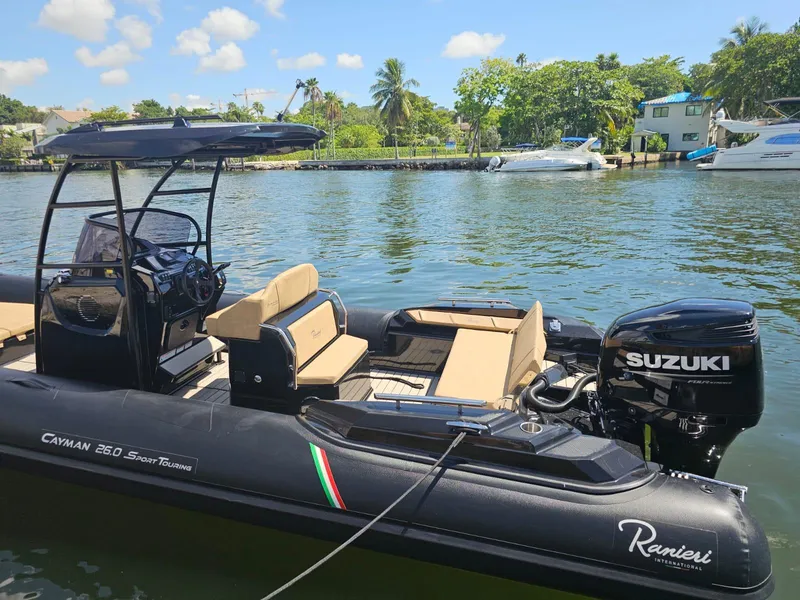 Slide: The Image of 2023 Ranieri CAYMAN 26 SPORT TOURING boat docked on a sunny day. - 2