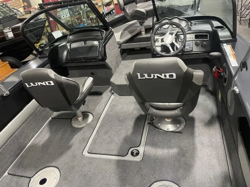 Slide: The Image of 2024 Lund 1875 Crossover XS Sport boat interior with seating and steering console. - 6