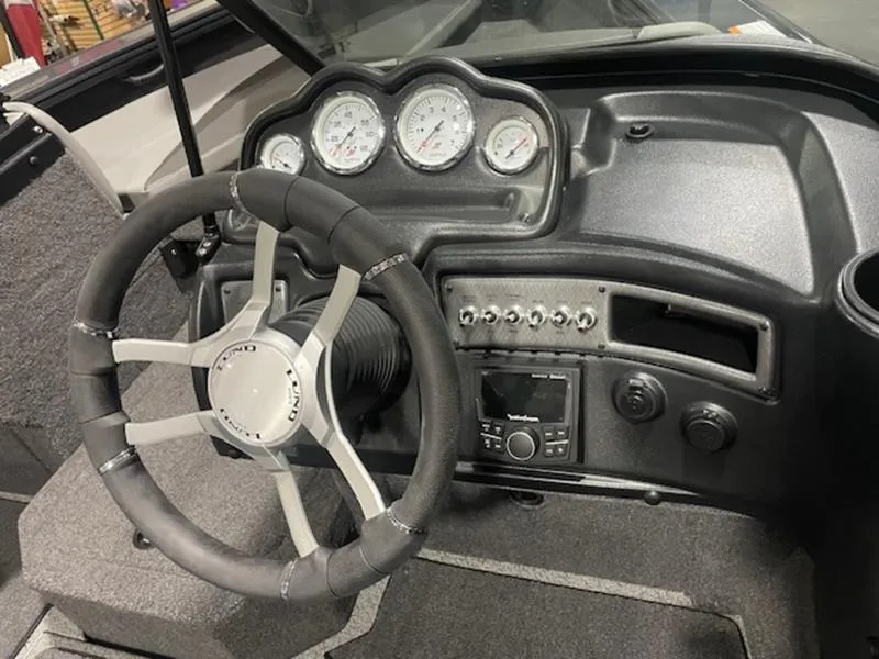 Slide: The Image of 2024 Lund 1875 Crossover XS Sport boat dashboard with steering wheel and gauges. - 8