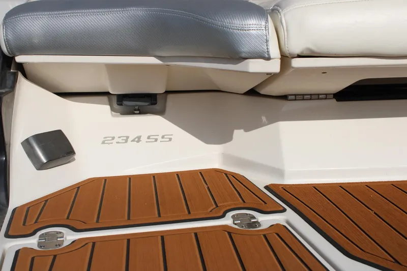 Slide: The Image of 2013 Monterey 234 SS boat interior with teak flooring and cushioned seating. - 7
