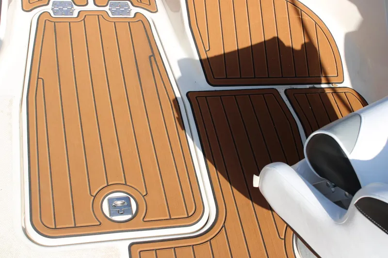 Slide: The Image of 2013 Monterey 234 SS boat interior with teak-style flooring and white seating. - 11